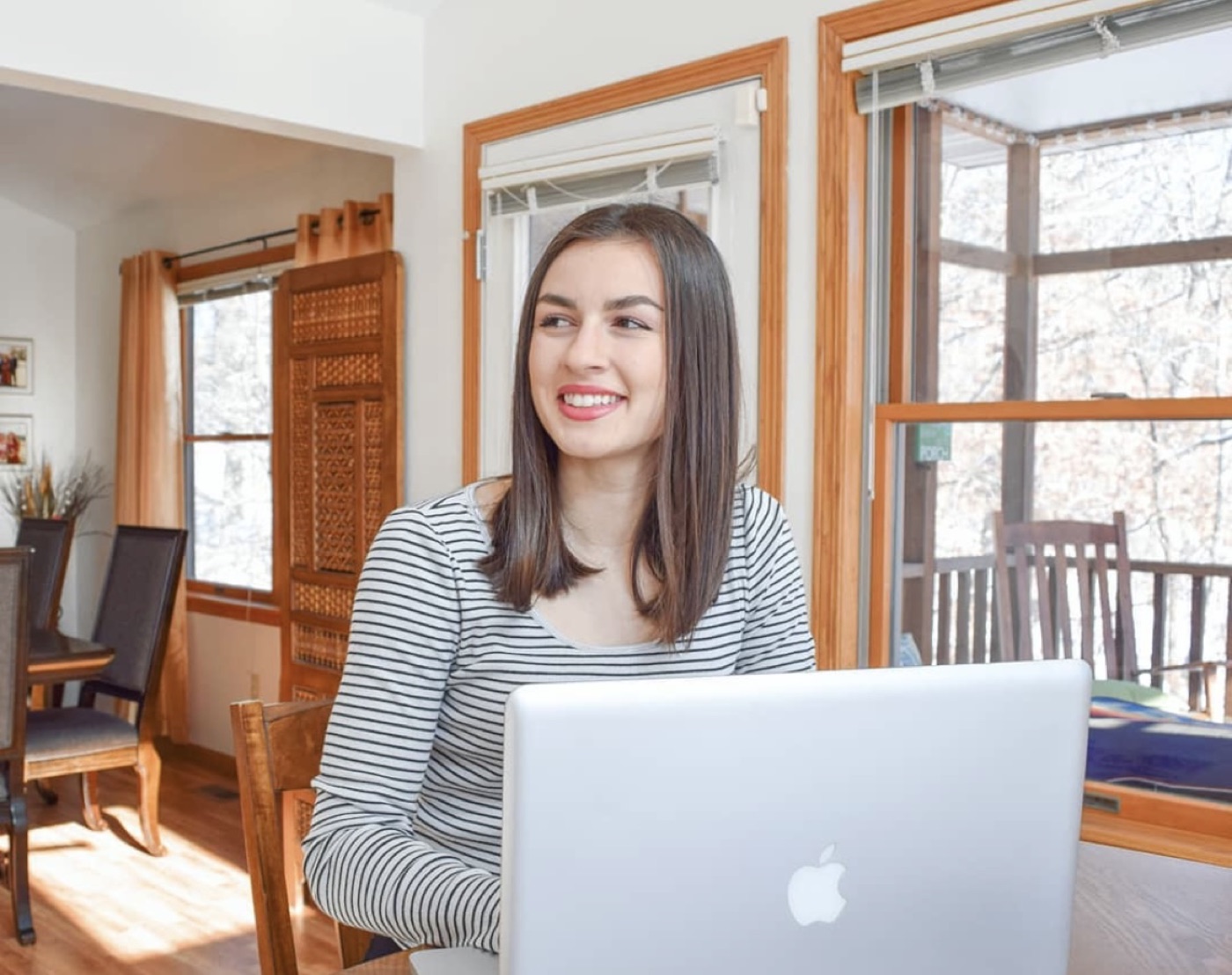 Lilly working on a laptop at a dining table